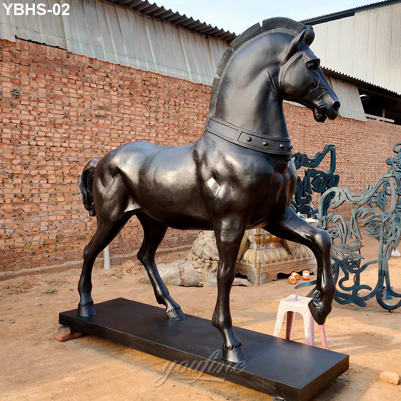Bronze horse sculpture with detailed mane, standing on a sturdy base in an outdoor setting