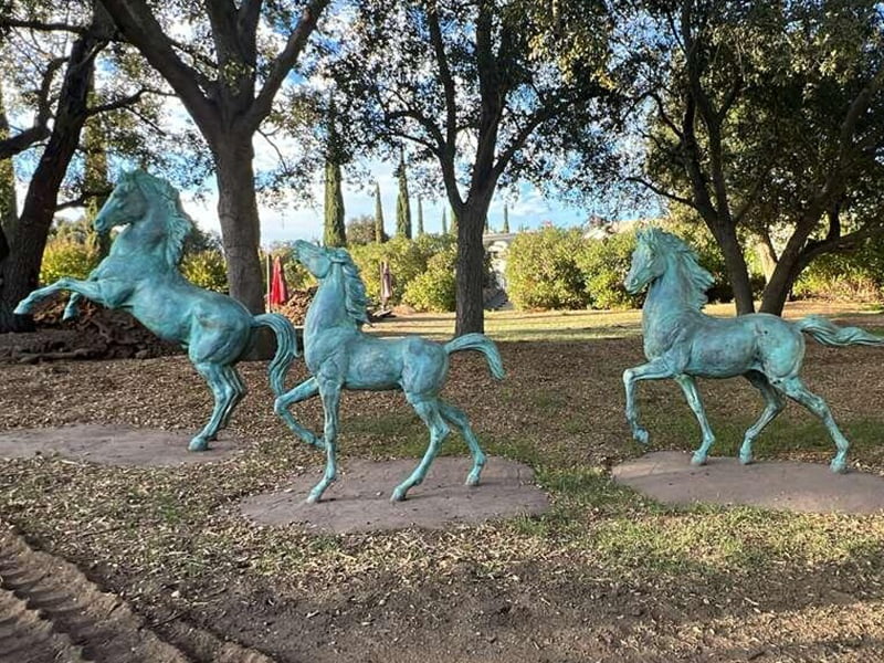 Monumental bronze horse racing group sculpture at an equestrian club in Australia