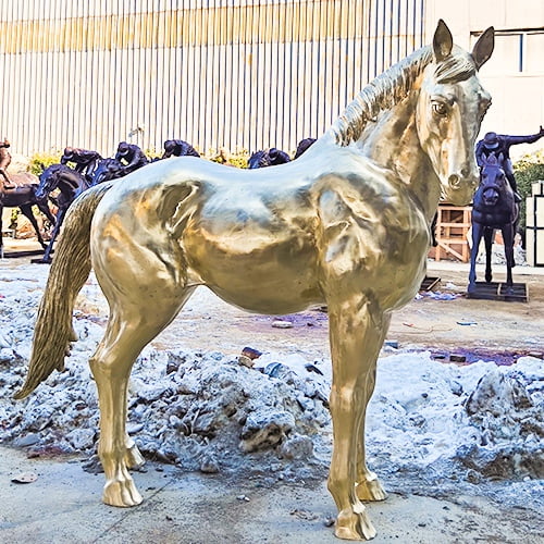 The welded and polished standing horse sculpture is placed outdoors