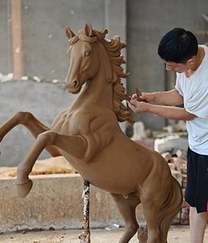 bronze horse sculpture workshop artisans working on clay model