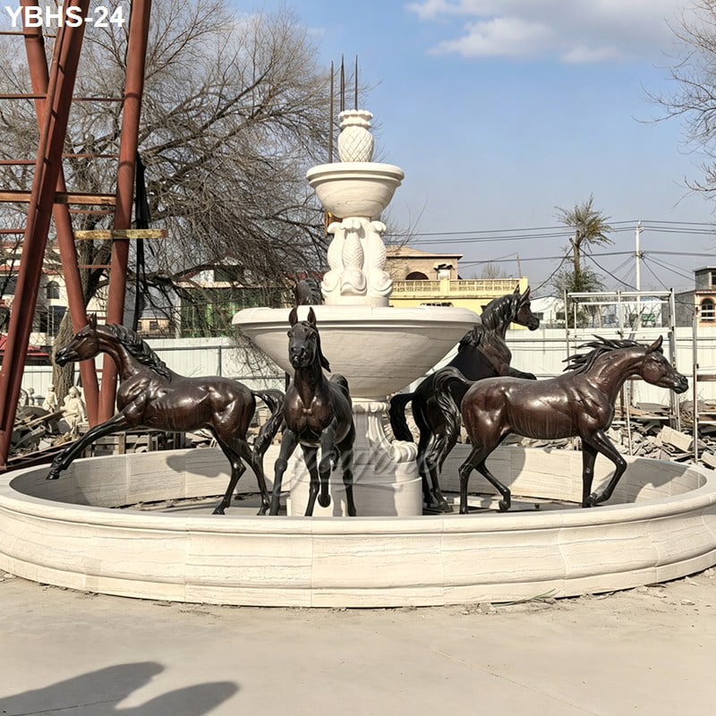 A circular fountain featuring intricately sculpted bronze horse statues surrounded by a stone base with a pineapple-topped central pillar.