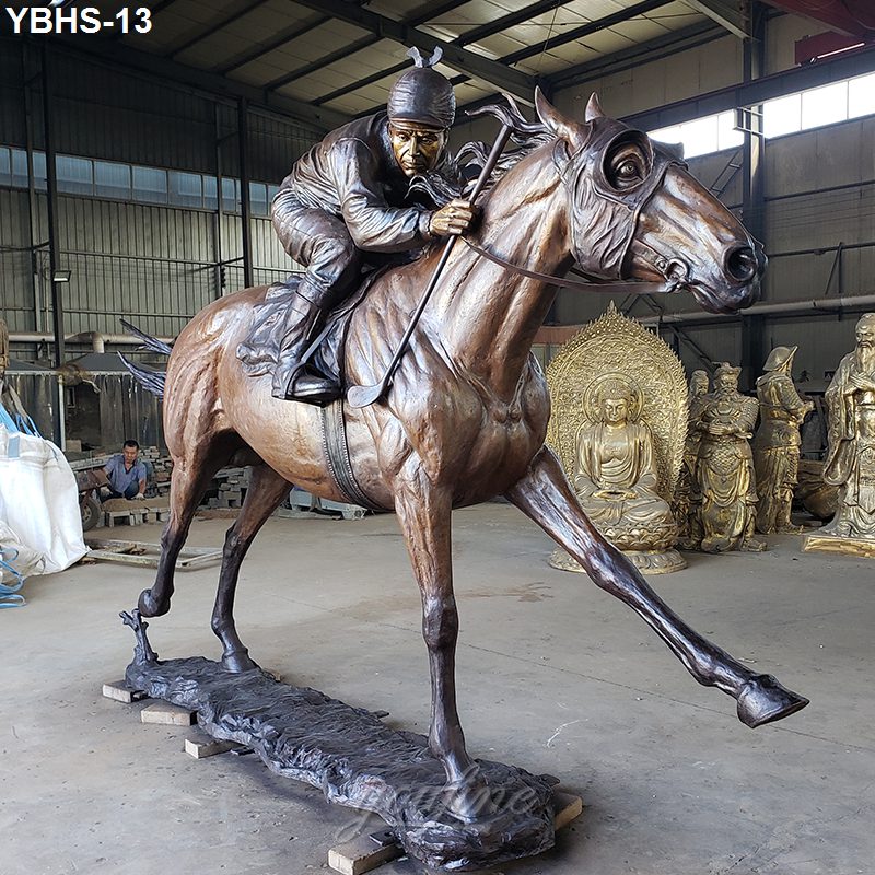 Life-size bronze horse and jockey statue showcasing dynamic movement indoors, surrounded by other sculptures in a production workshop.