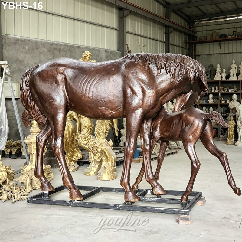 Bronze sculpture depicting a mare with her foal in an artisan workshop surrounded by various other statues and art pieces.