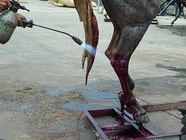 Chemical patina colouring applied to finished bronze rearing horse sculpture