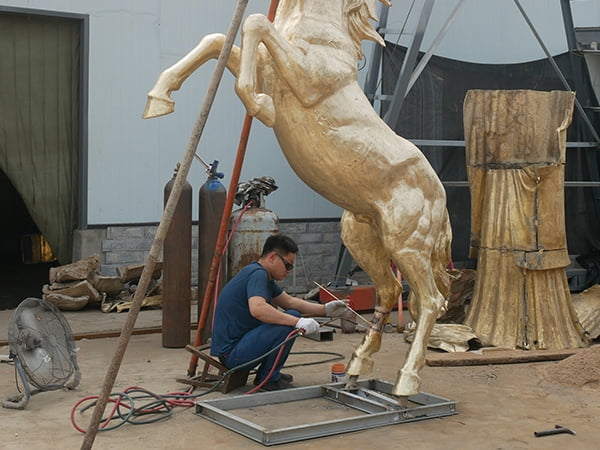 Expert welding of individual cast bronze sections into unified sculpture