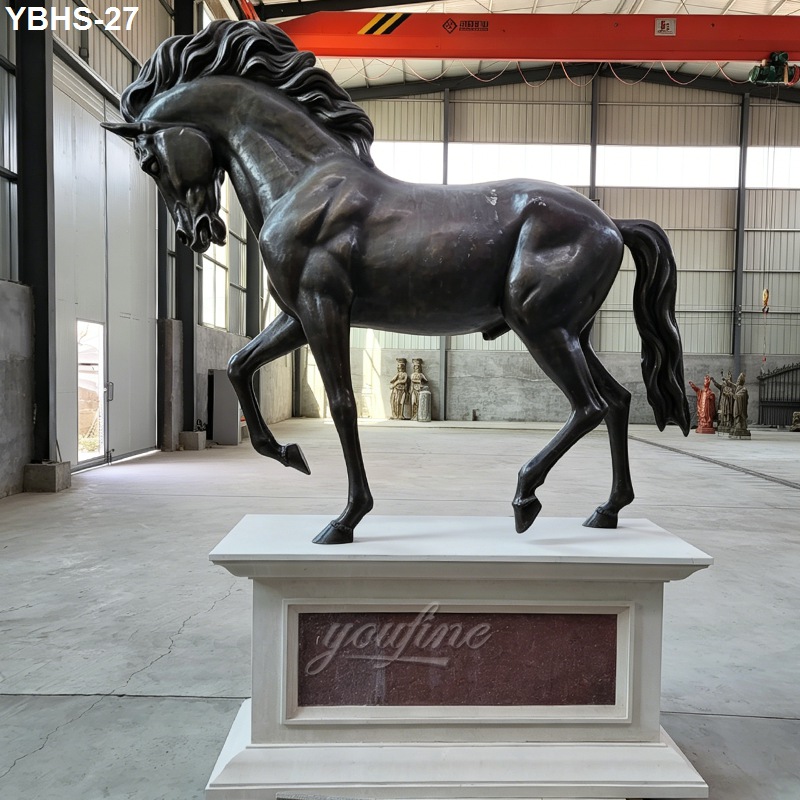 Bronze horse sculpture featuring dynamic pose and flowing mane, displayed indoors on a white base with industrial and artistic surroundings.