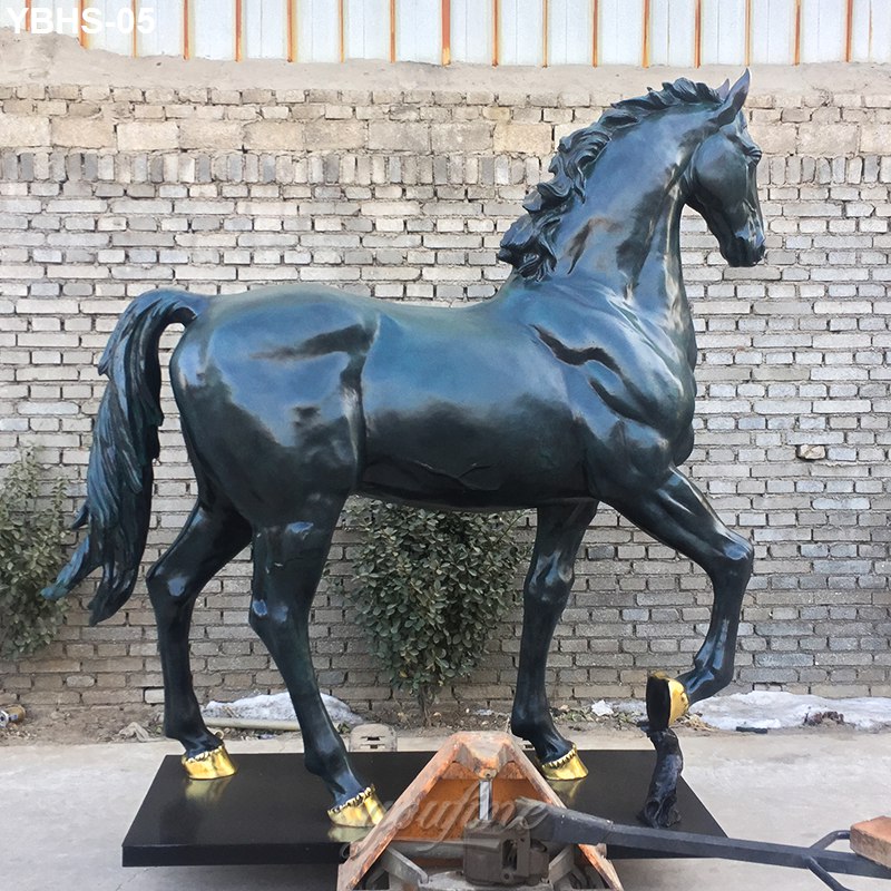 A large bronze horse statue in a majestic stance with detailed musculature and gold-accented hooves