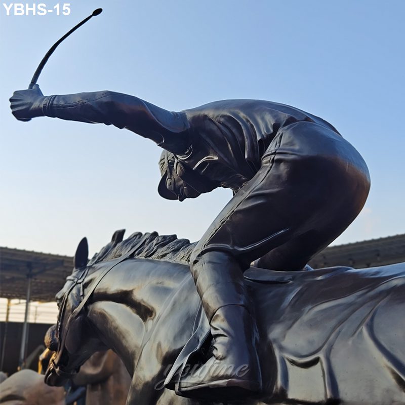 A detailed bronze sculpture of a jockey leaning forward energetically on a galloping horse, set against an outdoor backdrop.