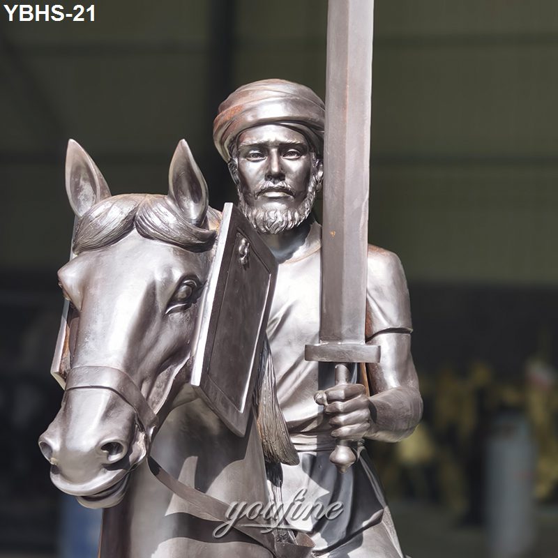A detailed bronze statue of a knight holding a sword and shield, riding a horse with intricate features, in an indoor setting.