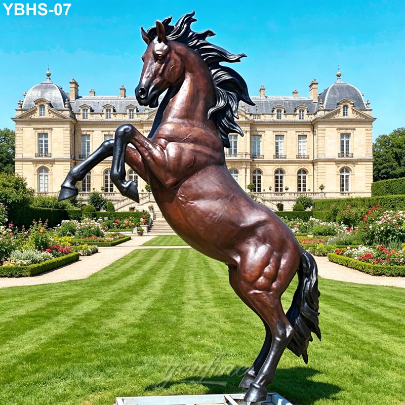 A detailed bronze sculpture of a rearing horse displayed in an elegant castle garden with manicured lawns and vibrant flowers.