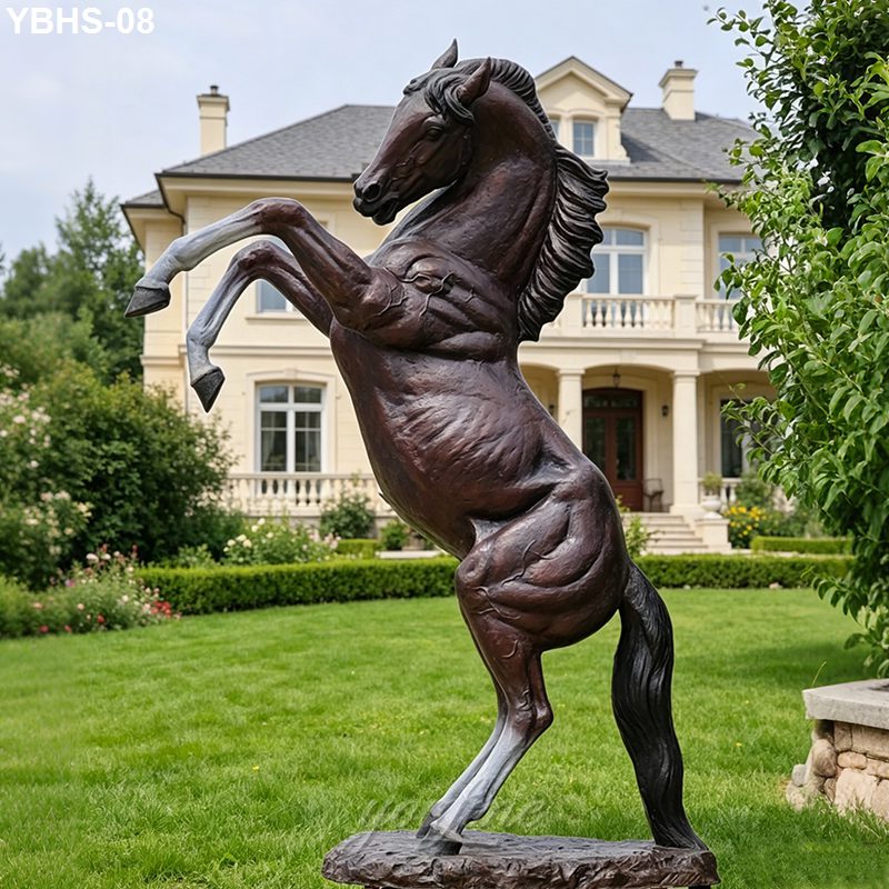 A bronze sculpture of a rearing horse on lush green lawn in front of an elegant mansion, emphasizing prestige and artistry.