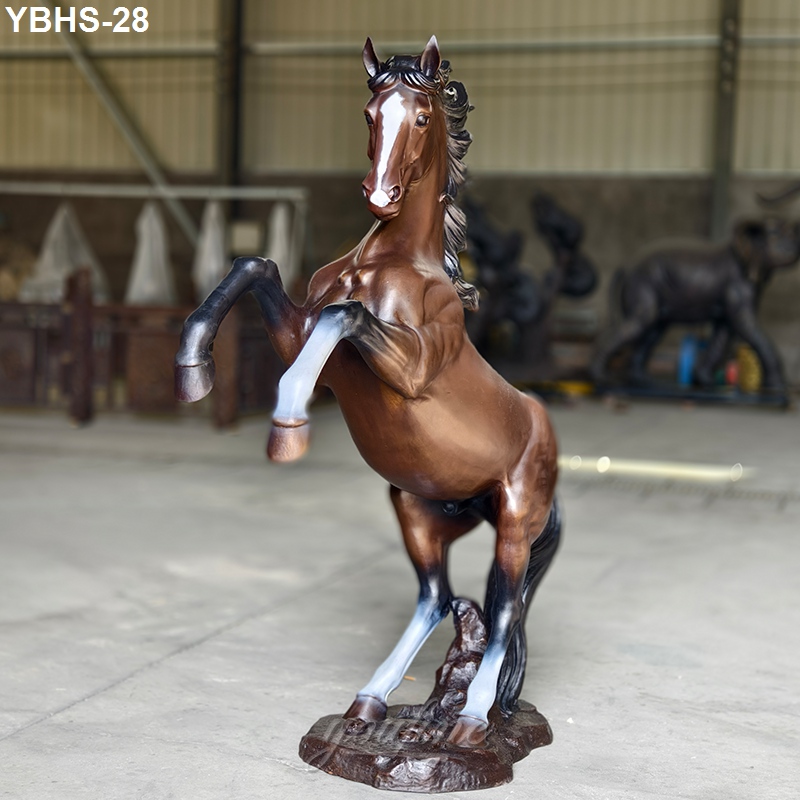 Detailed bronze sculpture of a rearing horse with raised forelegs in a workshop setting, showcasing craftsmanship and equestrian artistry.
