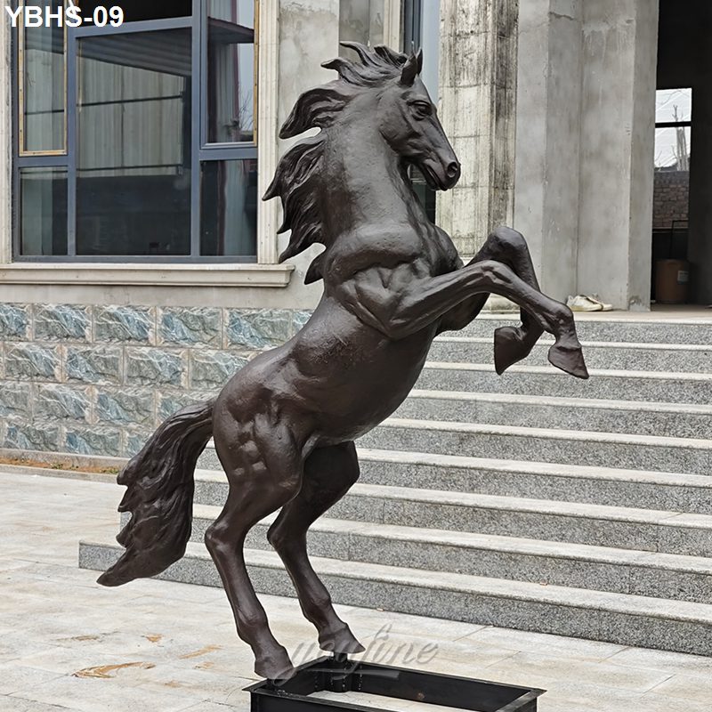Bronze horse sculpture depicting a rearing horse with flowing mane outside a modern stone and glass building.