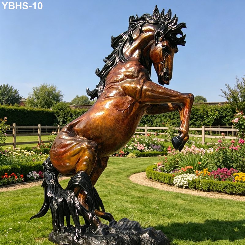 A bronze sculpture of a rearing horse with intricate detailing, set in a manicured garden with flowers and hedges.