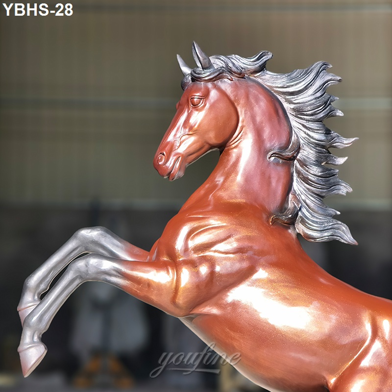 Bronze sculpture of a rearing horse with a vivid red and silver finish, intricate flowing mane, and expressive details.