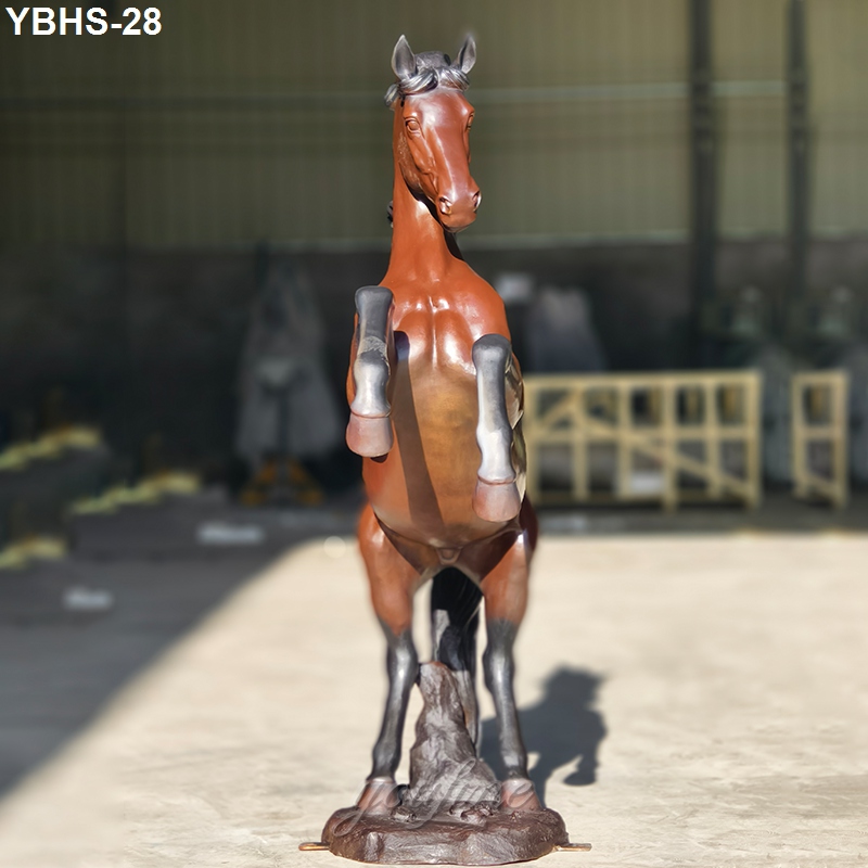 Detailed bronze horse sculpture rearing on hind legs, displayed in a well-lit workshop with visible craftsmanship.