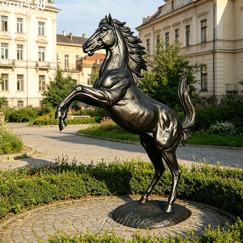A polished bronze horse sculpture rearing on a circular plinth, surrounded by landscaped greenery and elegant buildings in the background.