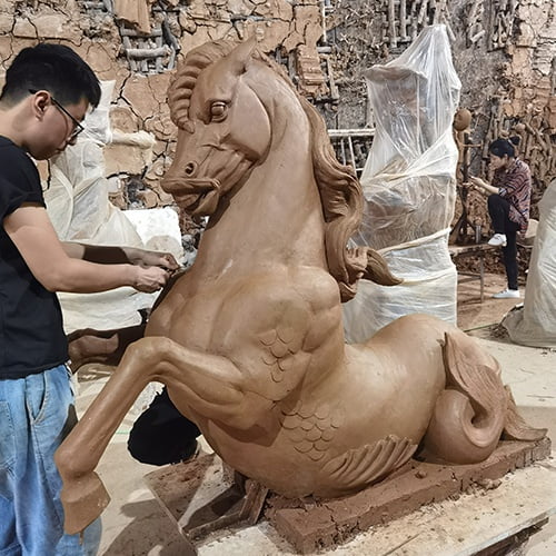 The craftsman is making a horse clay model