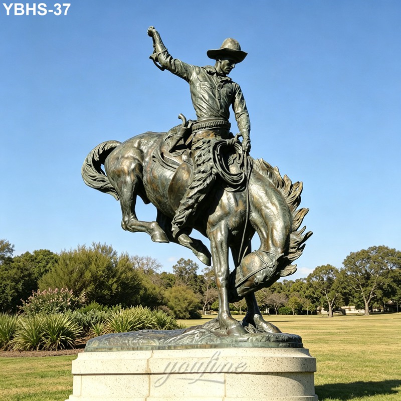 Bronze sculpture of a cowboy riding a bucking horse, placed on a stone pedestal in a sunny outdoor park or estate.