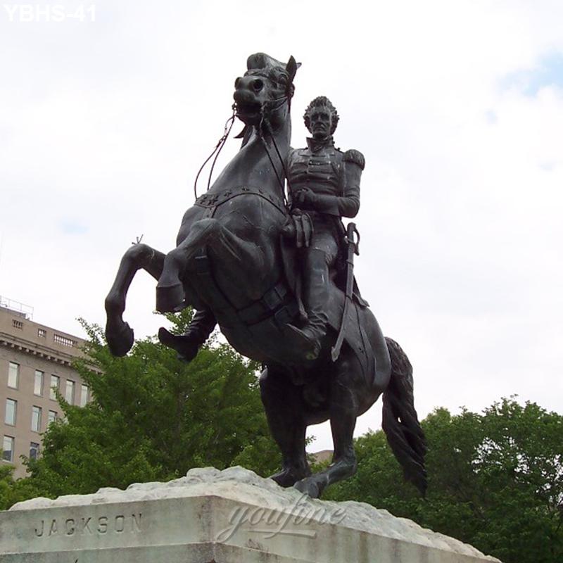 Bronze equestrian statue of a rider and a rearing horse, mounted on a stone pedestal inscribed with 'Jackson,' surrounded by trees and buildings.