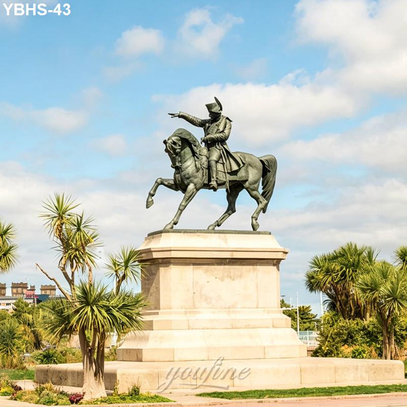 A bronze equestrian statue on a stone pedestal, featuring a rider pointing forward. Surrounded by palm trees and set against a blue sky.