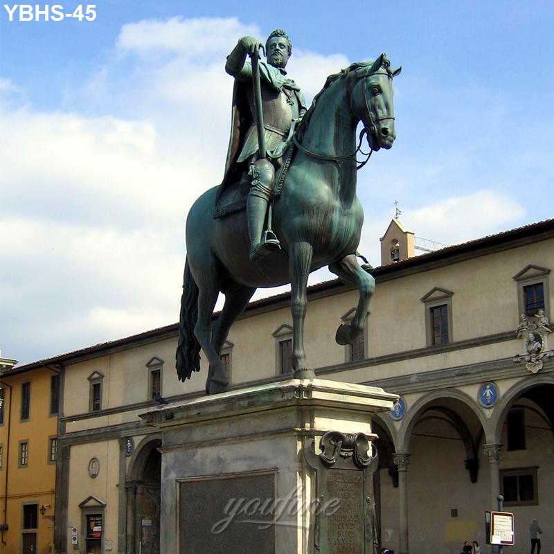Bronze equestrian statue featuring a rider on horseback, set on a pedestal in a historic plaza with arched buildings in the background.
