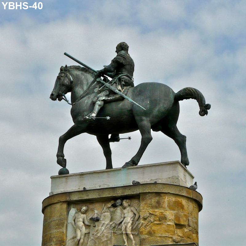 Bronze equestrian statue of a rider holding a spear, atop a decorated stone pedestal with cloudy sky in background.