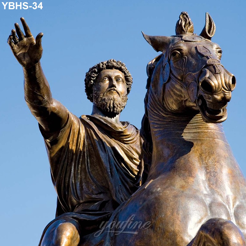 Bronze statue of a rider on a rearing horse, with the figure raising one arm, depicted against a clear blue sky.