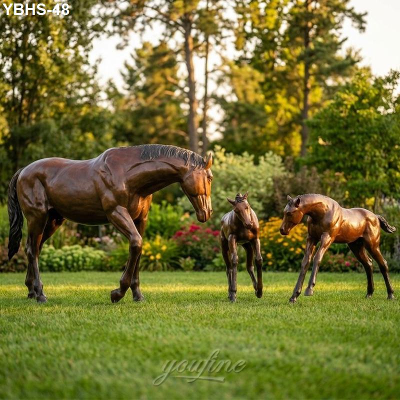 Bronze sculptures of a horse with two foals displayed outdoors in a lush garden, symbolizing elegance and heritage.