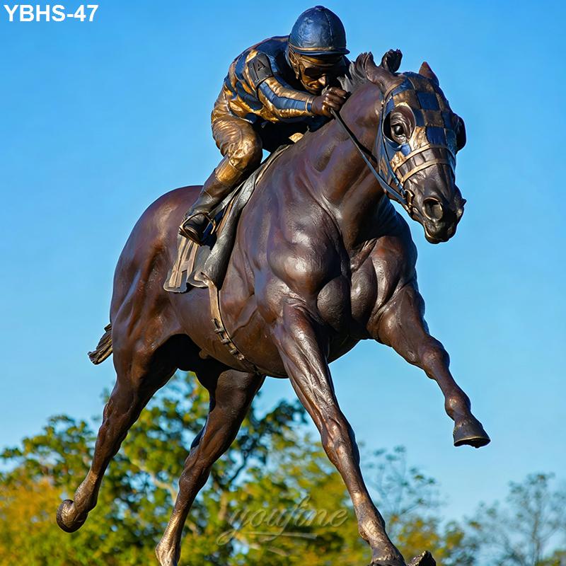Bronze sculpture of a horse in full stride with a jockey dressed in patterned racing gear, captured against a blue sky background.