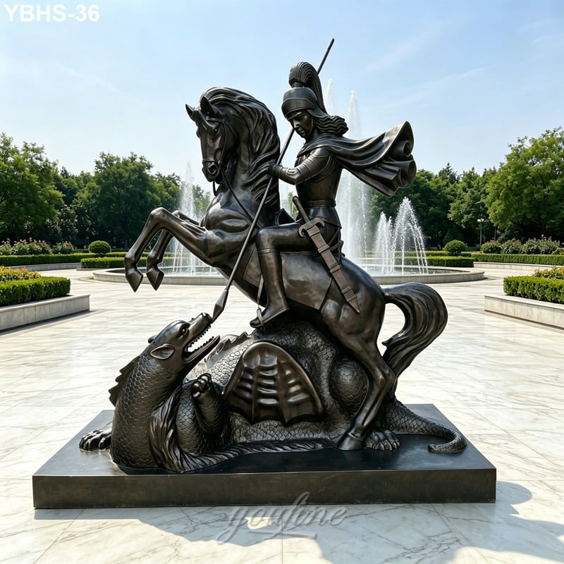 Outdoor bronze sculpture of a horse and rider slaying a dragon with a lance, placed on a marble platform near fountains and greenery.