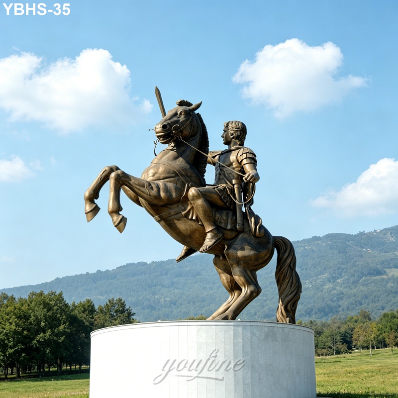 A bronze statue of a medieval-style rider on a rearing horse atop a pedestal, set against a scenic backdrop of mountains and trees.