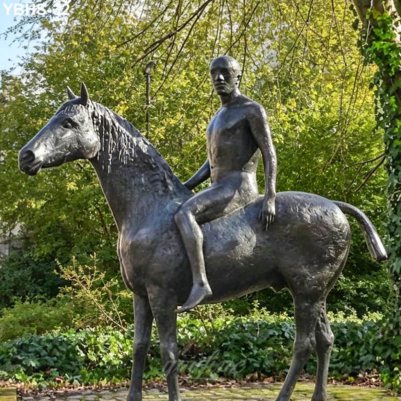 A detailed bronze sculpture of a horse with a rider seated atop, set in a lush garden with greenery and natural surroundings.
