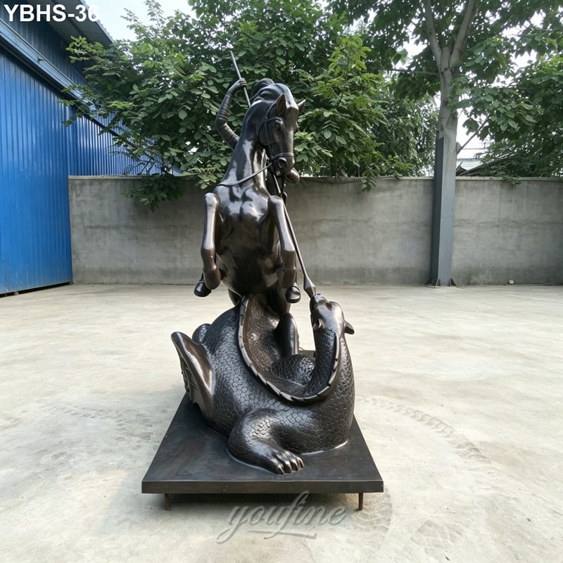 Bronze statue depicting a rearing horse and rider combatting a menacing dragon, displayed in an outdoor courtyard with trees and walls.