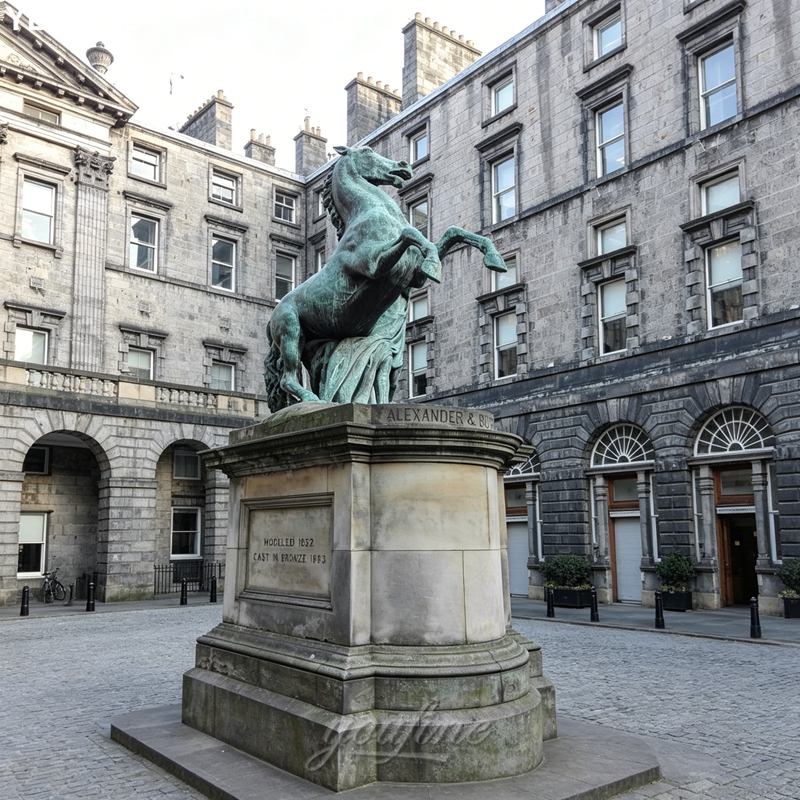 A bronze horse statue on a stone pedestal in a historic courtyard surrounded by classical stone buildings with arched windows.