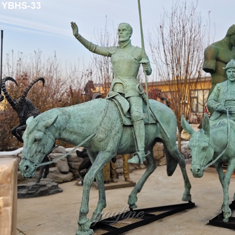 Life-size bronze sculpture of a knight in armor on horseback, raising one hand, with a spear in the other. Outdoor setting with additional statues.