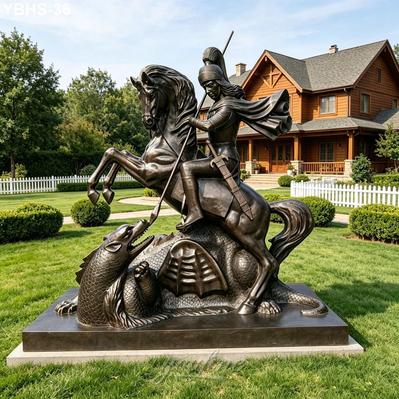 Majestic bronze sculpture of a knight on horseback slaying a dragon, displayed on a lush green lawn in front of a wooden estate.