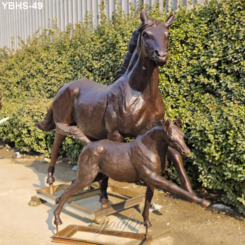 Bronze sculpture of a mare and foal with detailed craftsmanship, placed outdoors against greenery, symbolizing strength and heritage.