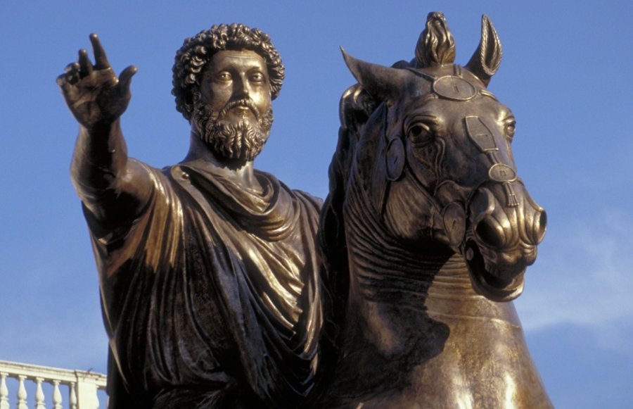 A bronze equestrian statue showing a historical figure on horseback with arm raised, against a clear blue sky.