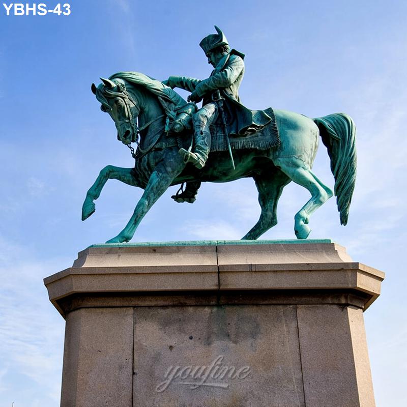 Bronze equestrian statue of a rider in detailed military attire atop a horse, mounted on a stone pedestal against a clear sky.