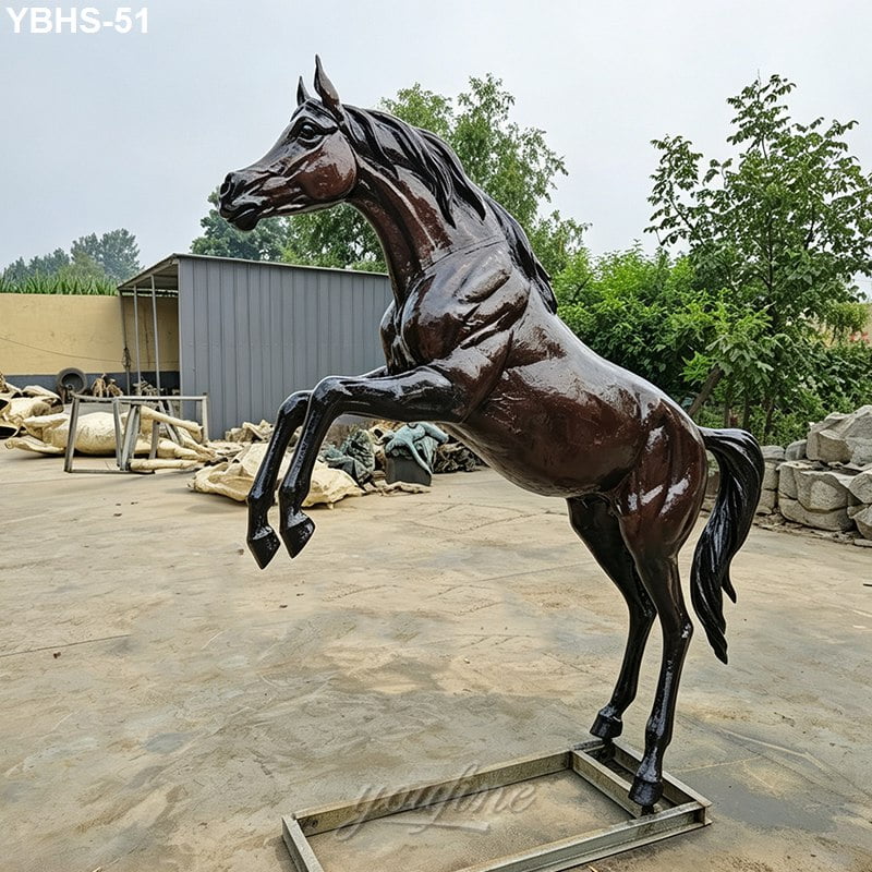 Lifelike bronze horse statue in a rearing pose displayed outdoors, showcasing intricate details and polished surface.