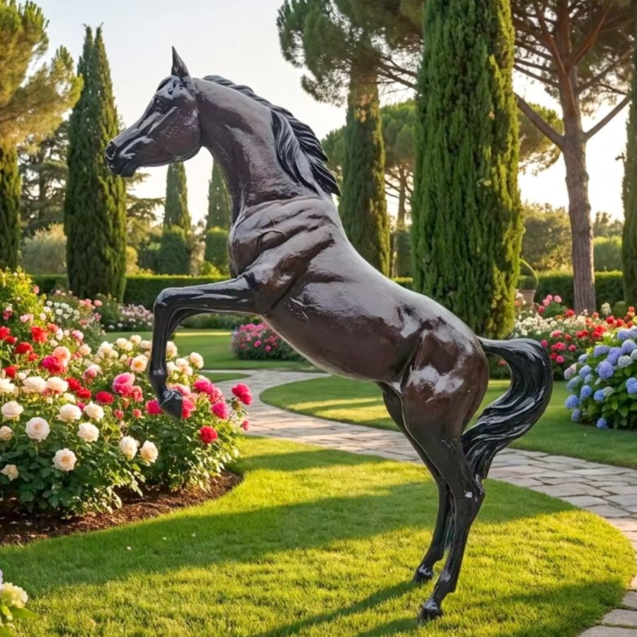 Life-size Arabian bronze horse sculpture installed in a high-end manor garden with vibrant flowers and stone path under warm sunlight