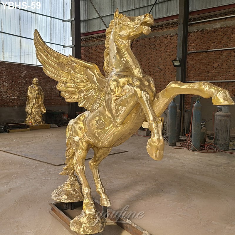 A colorless winged horse sculpture rearing up inside a workshop